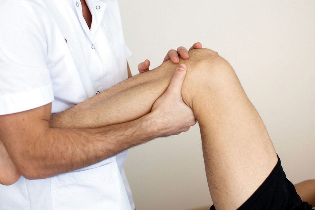 medico che esamina un ginocchio con artrosi
